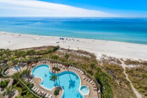 The view of a pool and beach area of a resort in Panama City Beach near some of the best local restaurants.